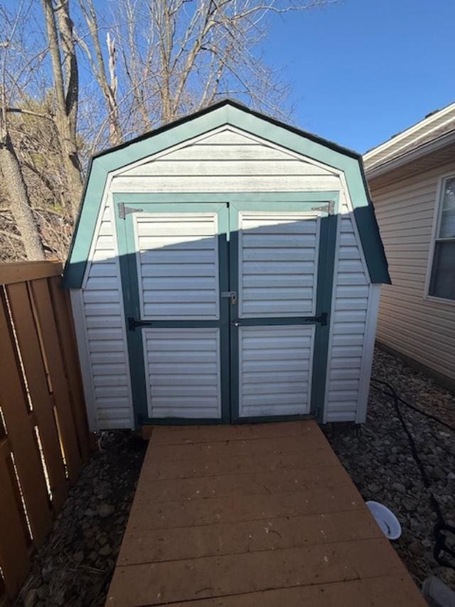 view of shed with driveway and fence