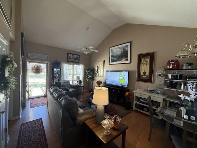 living area with high vaulted ceiling, ceiling fan with notable chandelier, and wood finished floors