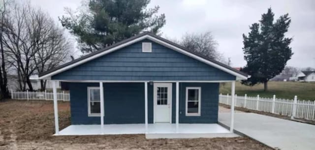 back of property with an outbuilding and fence