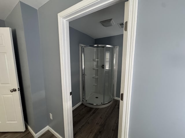 full bath with visible vents, a shower stall, baseboards, and wood finished floors