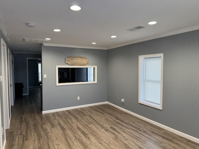 empty room featuring dark wood finished floors, crown molding, recessed lighting, visible vents, and baseboards