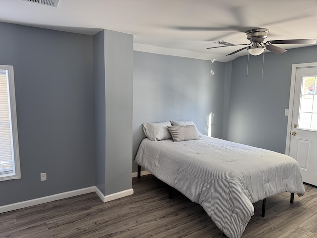 bedroom with a ceiling fan, visible vents, baseboards, and dark wood-type flooring