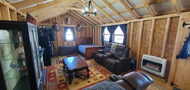 bedroom featuring a glass covered fireplace, vaulted ceiling, and heating unit