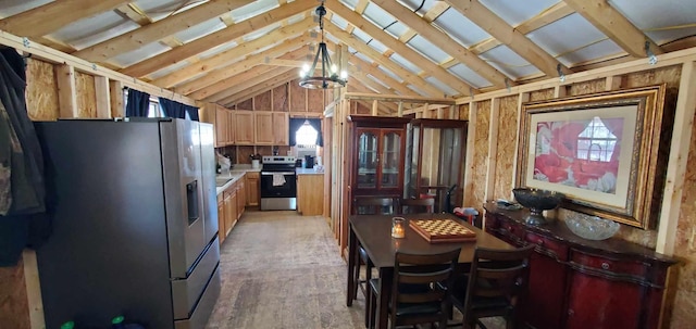 kitchen with lofted ceiling, wood finished floors, light countertops, appliances with stainless steel finishes, and pendant lighting