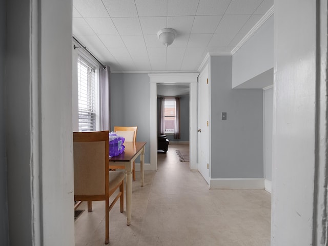 dining room featuring plenty of natural light, baseboards, and crown molding