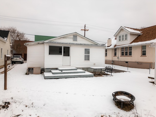 snow covered house featuring an outdoor fire pit