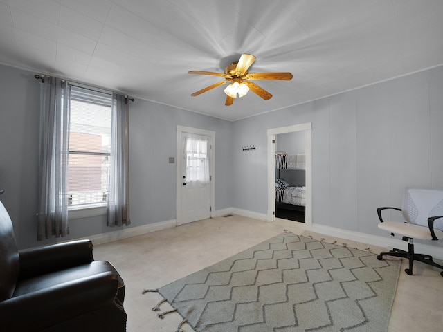 foyer entrance featuring a ceiling fan, ornamental molding, and baseboards