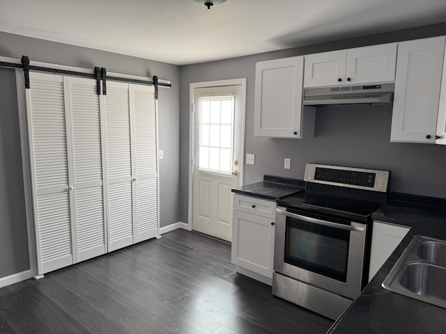 kitchen with electric range, dark countertops, white cabinetry, and under cabinet range hood