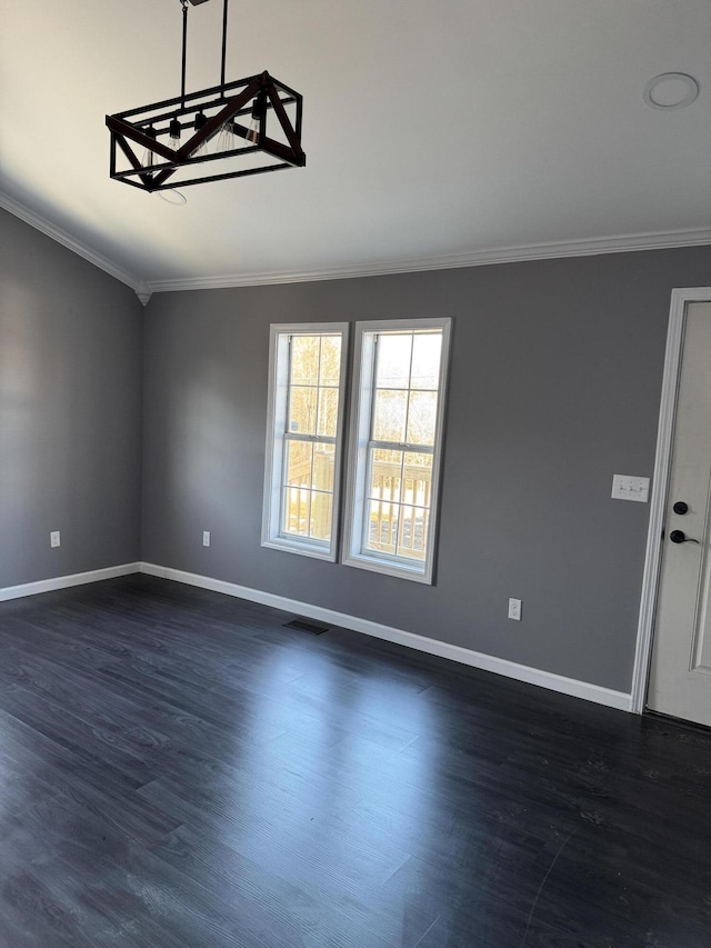 empty room with dark wood-style floors, baseboards, and ornamental molding