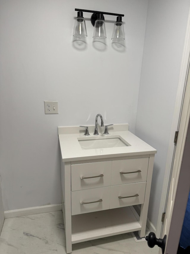 bathroom featuring marble finish floor, vanity, and baseboards