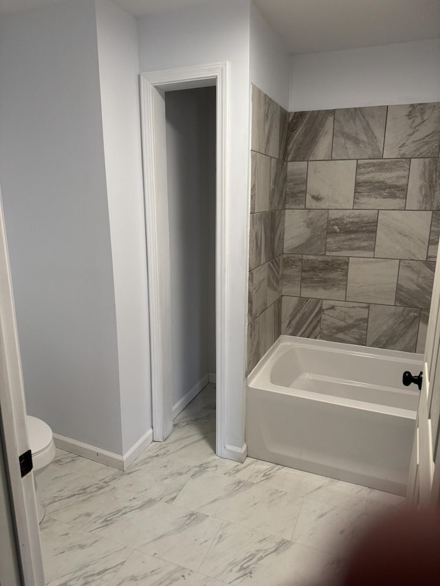 full bathroom featuring toilet, marble finish floor, shower / bath combination, and baseboards