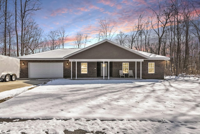 view of front of house featuring a garage, brick siding, and driveway