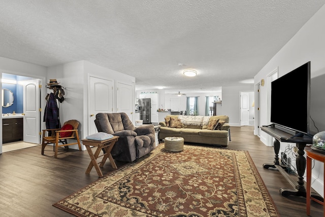 living area with a textured ceiling and wood finished floors