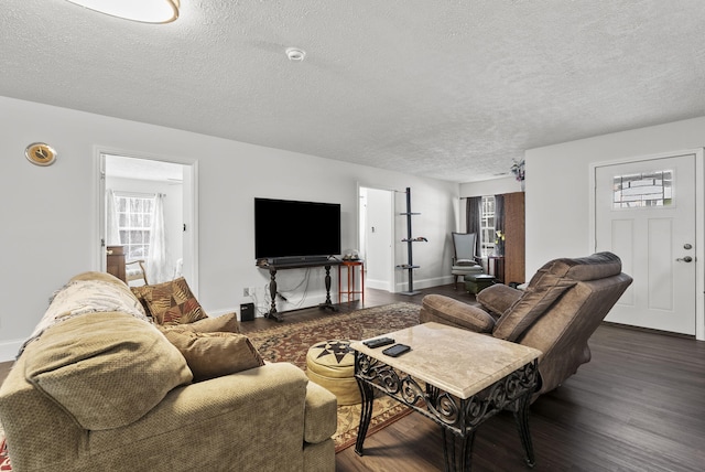 living room featuring a textured ceiling, baseboards, and wood finished floors