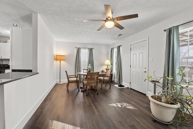 dining room featuring baseboards, visible vents, a ceiling fan, dark wood-type flooring, and a textured ceiling