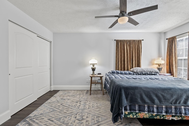 bedroom featuring a ceiling fan, a textured ceiling, baseboards, and wood finished floors