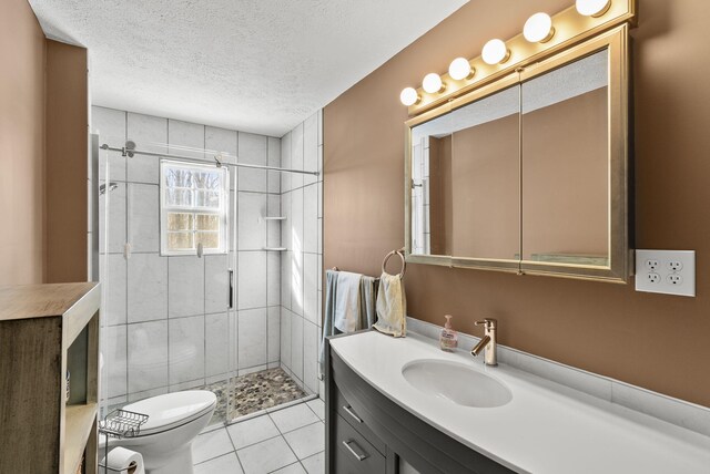 full bathroom featuring toilet, a stall shower, a textured ceiling, vanity, and tile patterned floors