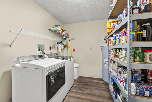 washroom featuring a textured ceiling, laundry area, wood finished floors, and washing machine and clothes dryer