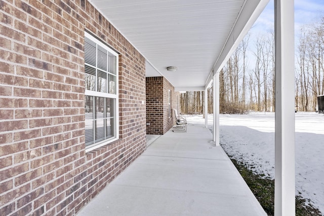 snow covered patio featuring a porch