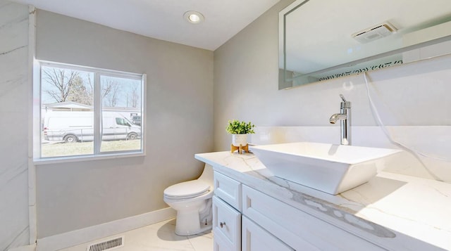 bathroom with visible vents, a healthy amount of sunlight, toilet, and vanity