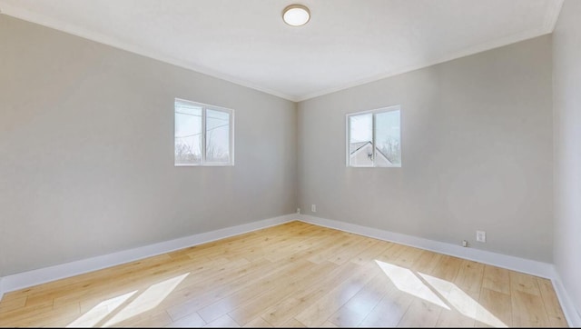 unfurnished room with a healthy amount of sunlight, baseboards, and hardwood / wood-style flooring