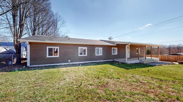 rear view of property featuring a patio, fence, and a lawn