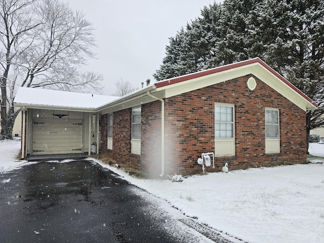 view of snowy exterior with brick siding