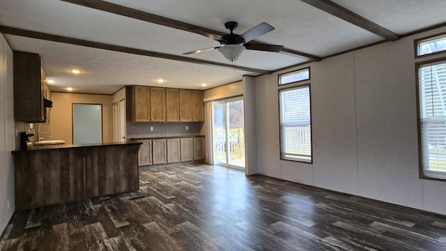 kitchen featuring plenty of natural light, dark wood finished floors, beam ceiling, and open floor plan