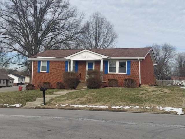 view of front of property featuring a front lawn and brick siding