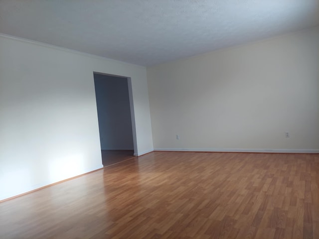 empty room featuring baseboards and light wood finished floors