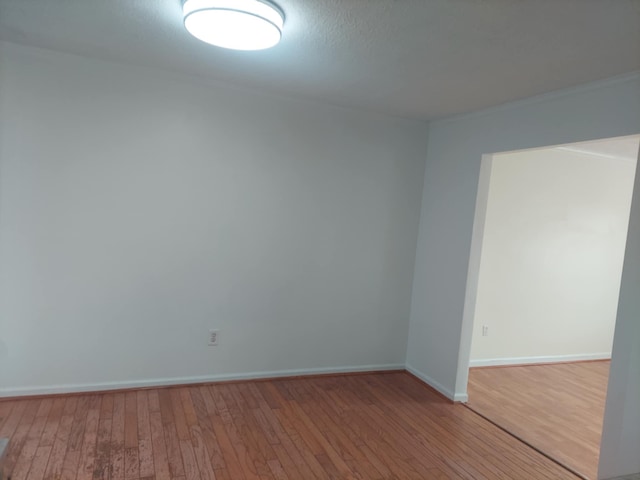 unfurnished room with light wood finished floors and baseboards