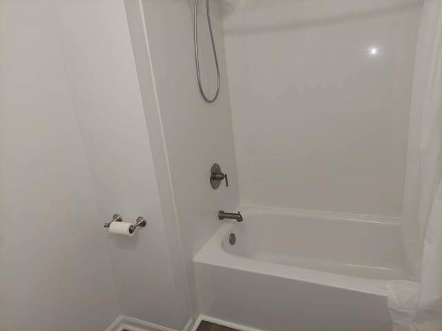 full bath with baseboards and shower / tub combo with curtain