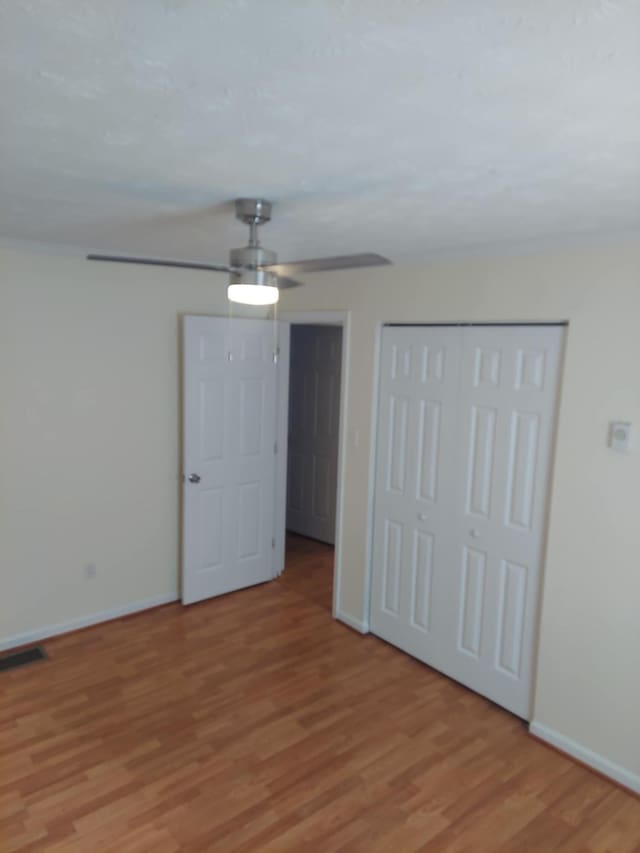 unfurnished bedroom featuring light wood-style flooring, a closet, visible vents, and baseboards