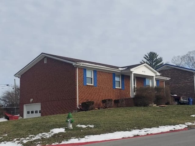 view of side of home featuring brick siding, a yard, and an attached garage