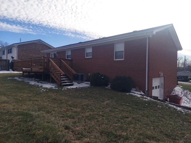 back of house with brick siding, a yard, stairway, and a wooden deck