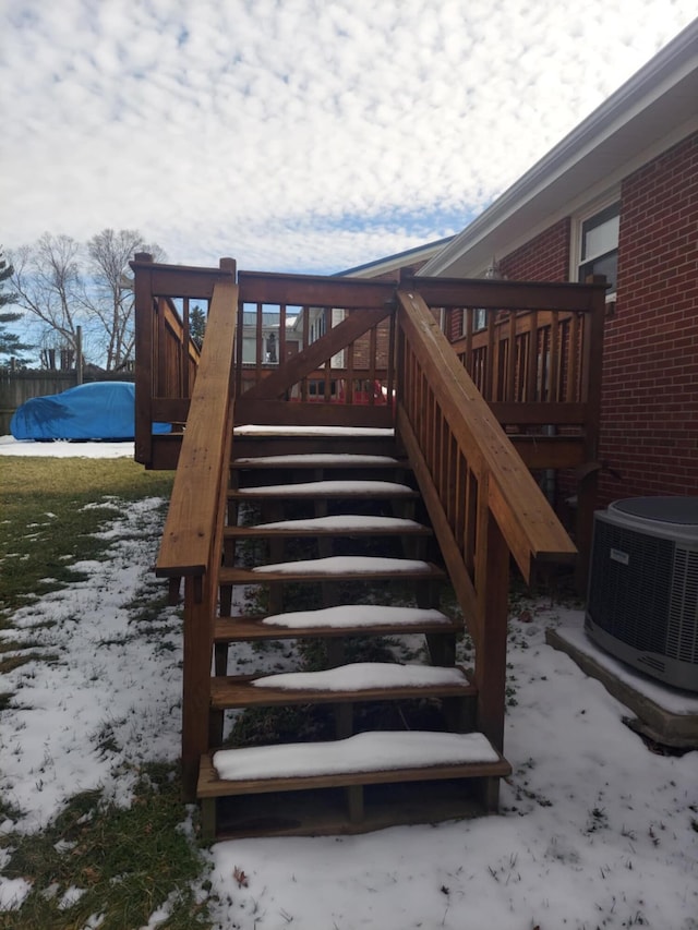 snow covered deck featuring stairs and central air condition unit