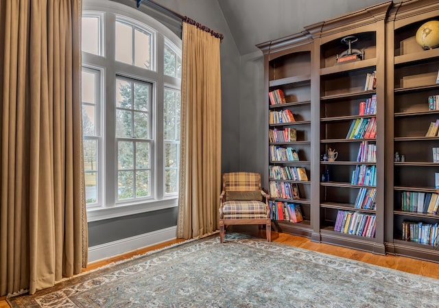 unfurnished room with lofted ceiling, baseboards, and wood finished floors