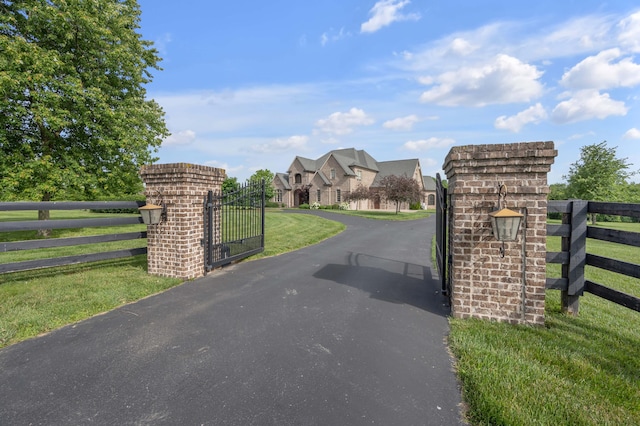 view of gate featuring a residential view, fence, and a yard