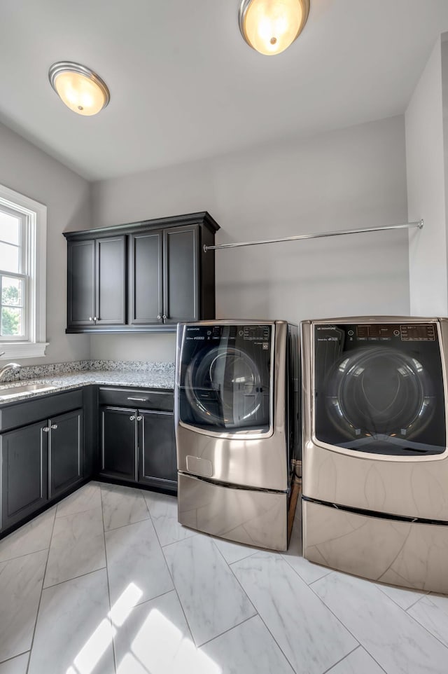 laundry room featuring washer and dryer, marble finish floor, cabinet space, and a sink