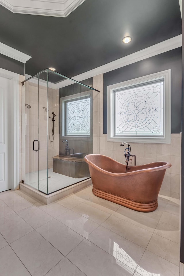 bathroom with ornamental molding, a stall shower, a freestanding tub, and tile walls