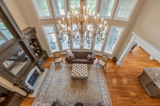 living room with a wealth of natural light, a fireplace, and a towering ceiling