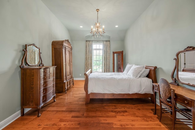 bedroom with a chandelier, recessed lighting, wood finished floors, baseboards, and vaulted ceiling