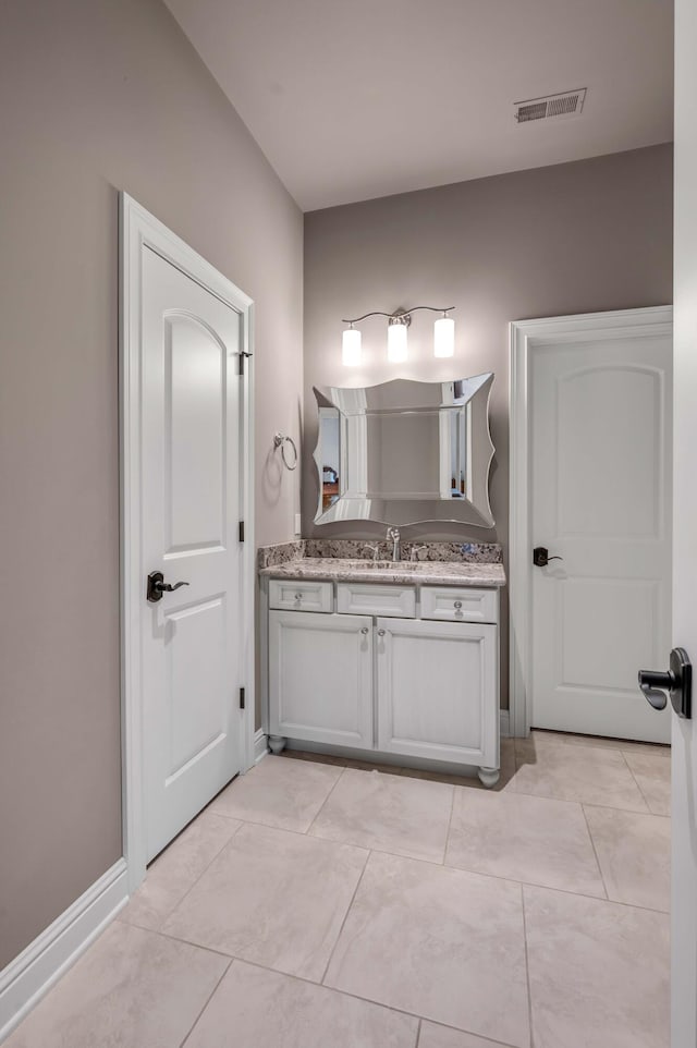 bathroom with tile patterned flooring, vanity, visible vents, and baseboards