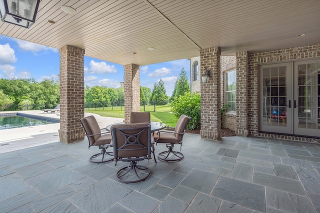 view of patio with french doors, an outdoor pool, and fence