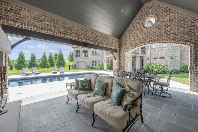 view of patio / terrace with outdoor lounge area, fence, and a fenced in pool