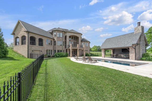 back of house featuring fence, a lawn, and a patio