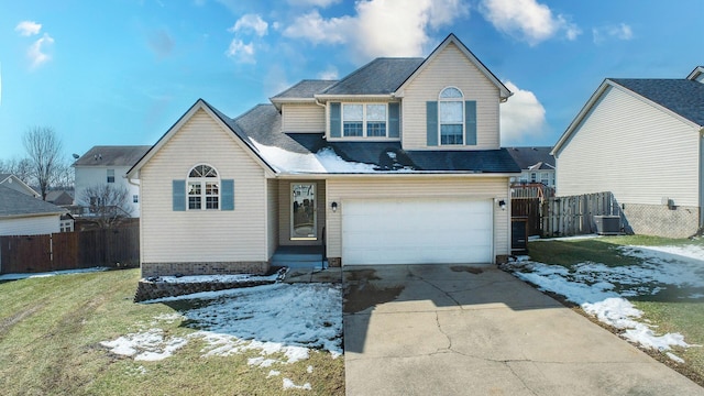 traditional home with an attached garage, central AC, fence, concrete driveway, and a lawn