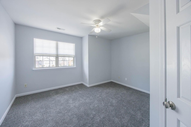 unfurnished room with ceiling fan, dark colored carpet, visible vents, and baseboards