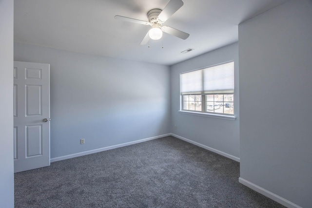 unfurnished room featuring a ceiling fan, dark carpet, visible vents, and baseboards