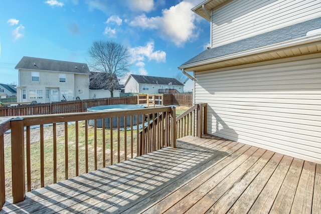 wooden deck with a residential view, a fenced backyard, and a lawn